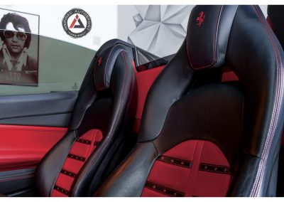 Luxury racing car seat interior with black leather, red detailing, and high-quality craftsmanship by Inspired Autosport.