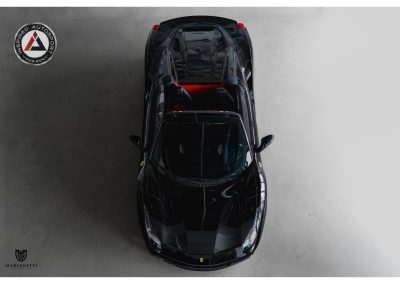 Sleek black Ferrari sports car photographed from above, showcasing its aerodynamic design, premium details, and high-performance features. Ideal for luxury auto enthusiasts and car collectors.