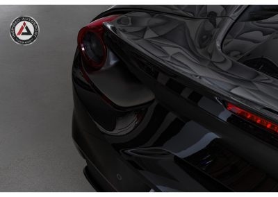 Close-up of a black luxury sports car showing modern rear taillight and aerodynamic curves, highlighting high-performance automotive design.