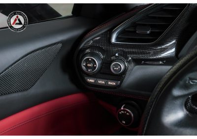 Detailed view of a racing car dashboard featuring carbon fiber elements, turbo controls, and advanced driving modes for motorsport enthusiasts.