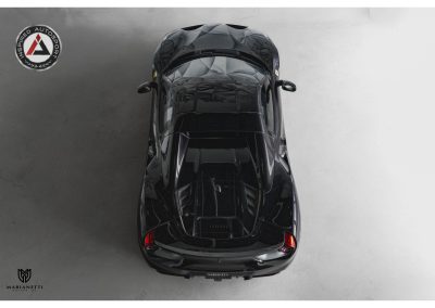 High-angle view of a sleek, black sports car showcasing advanced aerodynamic design and luxurious finish, emphasizing performance and style at Inspired Autosport.
