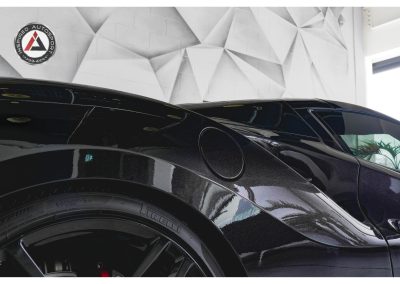 High-quality close-up of a sleek black sports car showcasing premium design and performance, displayed at Inspired Autosport automotive showroom.
